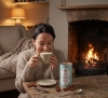 Person som är nöjd med en burk om 340 g chai tea latte-mix med vaniljsmak